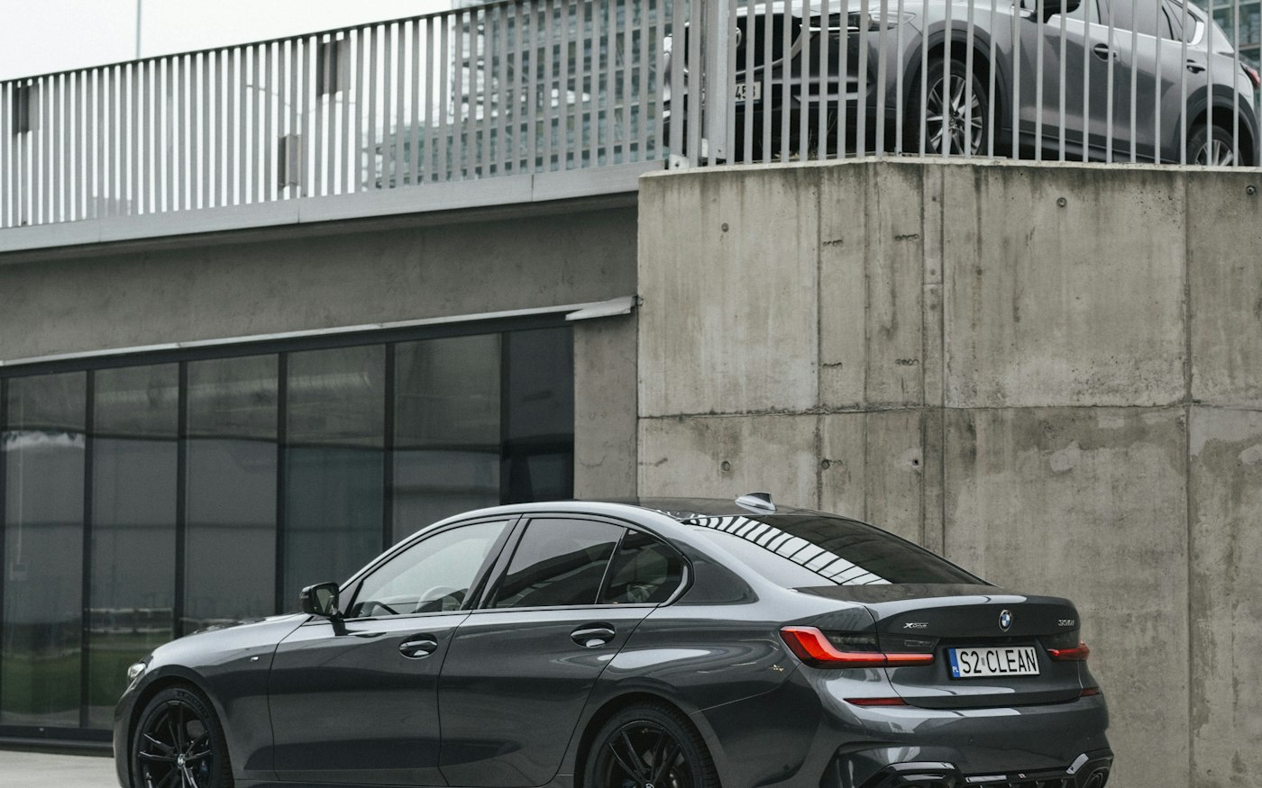Grafitowe BMW serii 3 przy nowoczesnym budynku